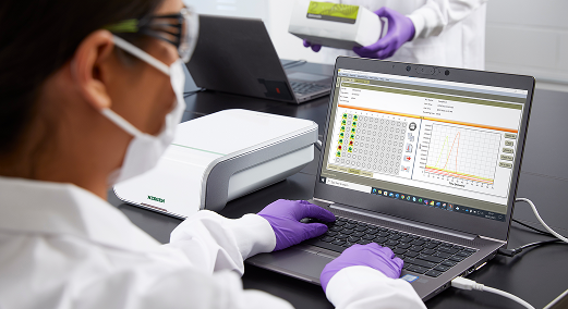 A lab technician loads the Neogen Molecular Detection Instrument and monitors pathogen test results.