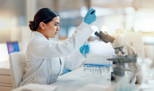 Food safety laboratory technician conducting microbiology testing and sample preparation using pipette