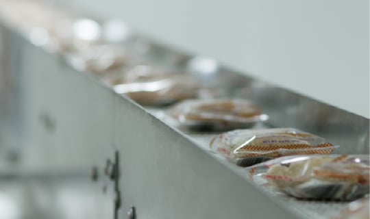 Packages of peanut-free product on a conveyor belt in a food processing facility