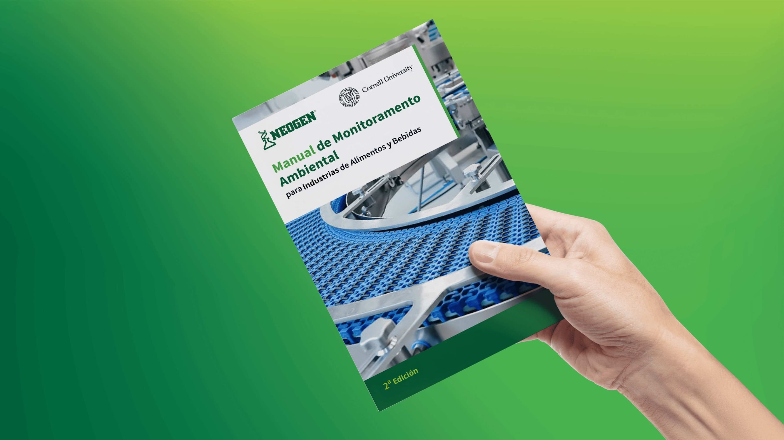 Mano sosteniendo el Manual de Monitoreo Ambiental de Neogen y Cornell University, 2da edición, para industrias de alimentos y bebidas – guía de inocuidad alimentaria y control de patógenos.