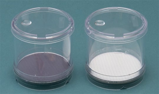 Laboratory filtration units with membrane filters for microbiological water testing.