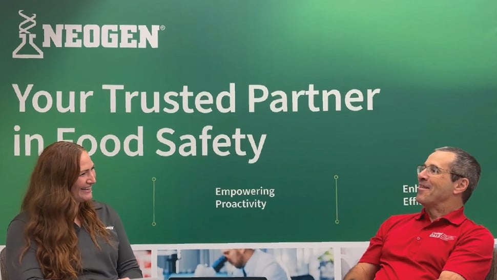 Two people discussing a topic during a trade show panel discussion.