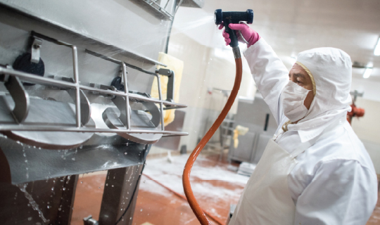Food manufacturing equipment being cleaned.