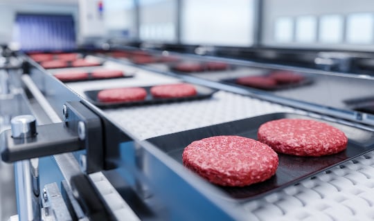 Image of beef patties being processed